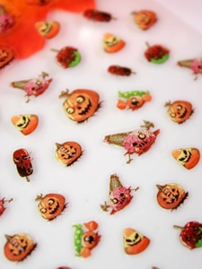Macro shot of Halloween 3D nail art decals with pumpkins and zombie brain motifs