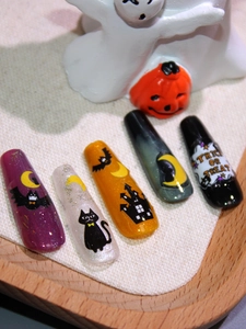 Detail of Halloween press-on nails featuring black cat, moon, and castle designs