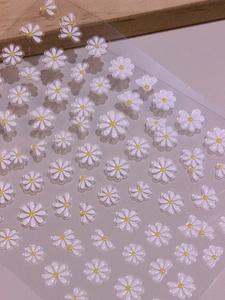 Detail of 5D white daisy nail art stickers with various sizes on transparent PET film