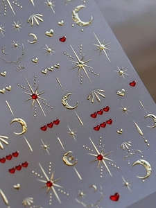 Macro detail of 3D gold embossed star and moon nail stickers with heart designs
