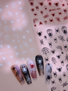 Detail of Halloween nail decals featuring spider and web patterns on model nails