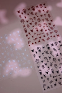 Detail view of Halloween spider web nail stickers in black, red and white, model DEC-023