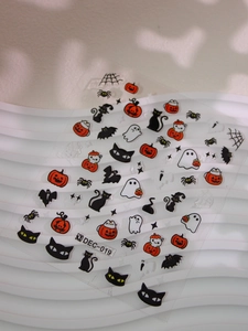 Detail of Halloween nail stickers with pumpkins and ghosts on wave texture background