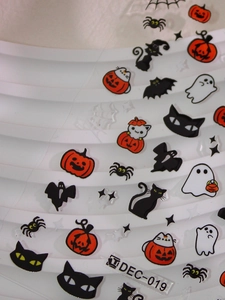 Detailed view of Halloween nail art stickers with pumpkin, ghost, and bat patterns