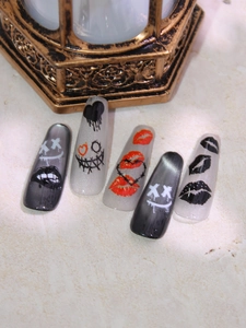 Détails de faux ongles longs avec motifs graffitis lèvres et finition œil de chat