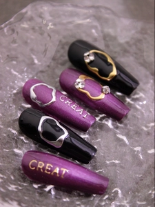 Macro shot of long trapezoid nails with 3D metallic rings, rhinestones and CREAT letters