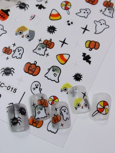 Detail of Halloween nail decals featuring cute pumpkins and black cats on grey manicured nails