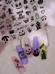 Detail of Halloween nail decals with black line art patterns on colorful nails