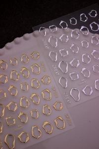 Close-up of 3D metallic gold and silver irregular loop self-adhesive nail art stickers