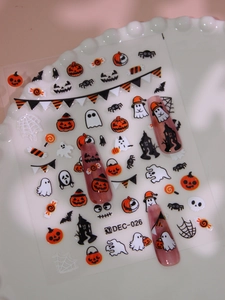 Close-up of Halloween nail decals featuring pumpkins and ghosts on a decorative plate