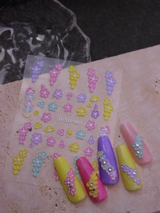 Macro view of 5D embossed floral nail art stickers with 3D texture and colorful petals