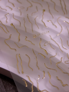 Macro shot of gold 3D wave line nail art stickers JY-0024 with metallic texture