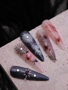 Macro detail of gothic Halloween press-on nails with 3D blood splatters and spider webs