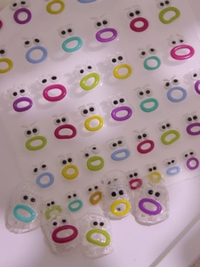Macro view of colorful embossed cartoon lip and eye nail art stickers with adhesive backing