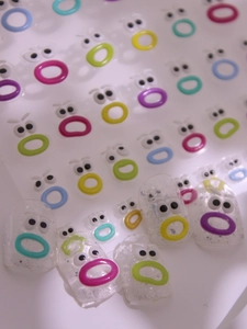 Macro detail of 3D embossed colorful lip and eye nail art stickers for DIY manicure