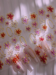 Vue détaillée de stickers 5D pour ongles aux bords dorés et textures en relief