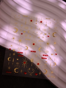 Detail of 3D gold embossed star and moon nail stickers with heart patterns, model M-861