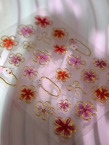 Vue détaillée des autocollants 5D pour ongles avec motifs floraux et bordures dorées