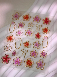Détail macro de stickers ongles 5D fleurs de cerisier avec contours dorés et nœuds