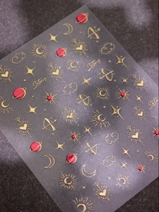 Macro detail of gold foil embossed nail art stickers with moon and star celestial designs