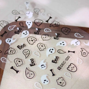 Halloween ghost nail art stickers with cute black and white decals on rustic background