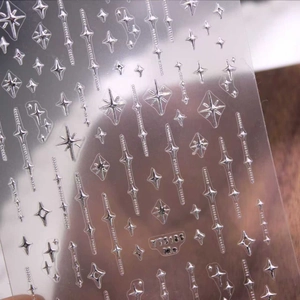 Stickers ongles étoiles 3D argent métallisé avec divers motifs sur fond de bois naturel