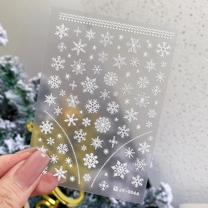5D embossed white snowflake nail decals with festive Christmas patterns on model's hand