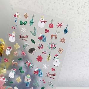 Handheld view of 3D Christmas nail art stickers with Santa and snowman patterns