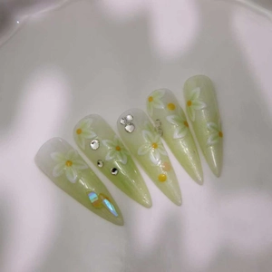 Faux ongles amande dégradé vert avec motifs fleurs marguerites et strass brillants