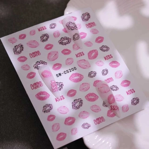 Detail of red leopard lip nail stickers with pink KISS design on matte white nails