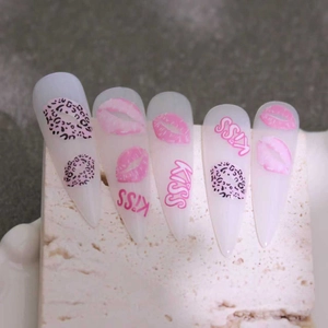 Macro detail of stiletto press-on nails with pink lip prints, leopard spots and KISS text