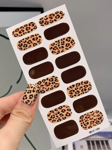 Detailed view of leopard print nail stickers and chocolate brown solid colors on nails