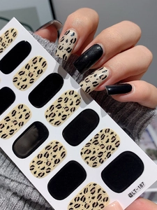 Close-up of autumn leopard print and black matte nail stickers on a model's hand