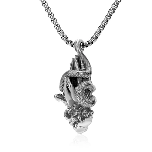 Detail of gothic praying hands pendant with wrapped snake on a vintage silver chain