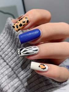 Close-up of square nail decals featuring leopard spots, zebra stripes, and blue finish