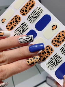 Detail view of leopard and zebra pattern nail stickers applied on natural nails with glossy finish