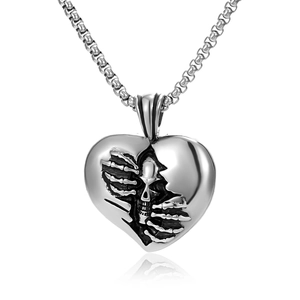 Detail of gothic heart-shaped cracked pendant with skull and bone hand inside