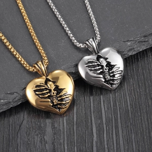 Gothic skull heart pendant necklaces in gold and silver finish on a dark stone base