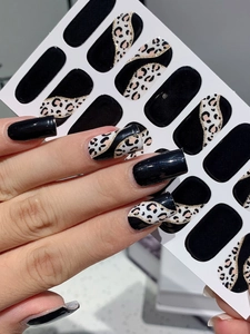 Detailed view of leopard print nail stickers with black finish and gold glitter lines