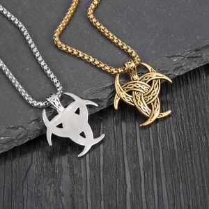 Detailed macro of Viking Odin's Horn pendants with intricate Celtic knots in gold and silver