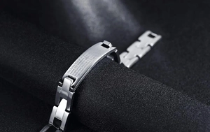 Macro view of stainless steel chain bracelet with engraved Lord's Prayer on silver plate