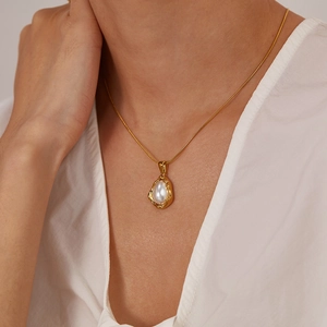 Détail d'un collier de perles vintage français avec pendentif goutte d'or sur un modèle