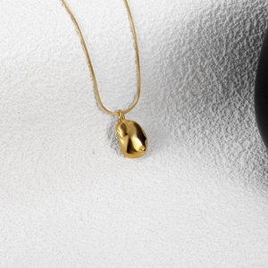 Elegant gold snake chain necklace with a polished organic pebble pendant for women