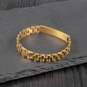 Detail of golden stainless steel link bracelet with rectangular matte ID plate finish