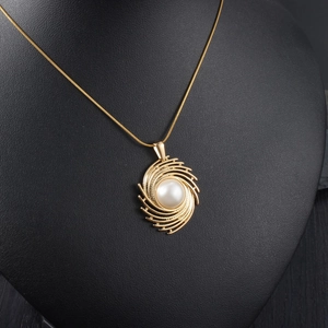 Elegant gold necklace with radial striped pendant and pearl on black neck display