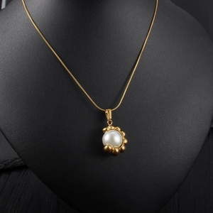 Collier plaqué or avec pendentif perle rayonnant sur support de bijoux noir élégant