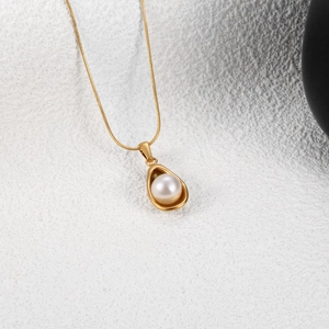 Collier minimaliste avec perle d'imitation et pendentif doré sur une chaîne serpent
