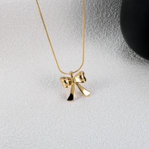 Polished minimalist bow pendant necklace with smooth snake chain in high-gloss gold finish