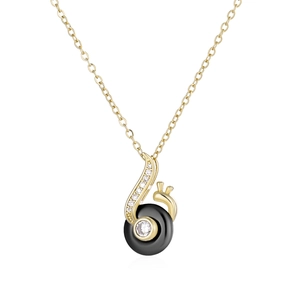 Detail of a gold snail pendant necklace featuring a black round inlay and sparkly zircon