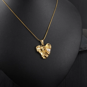 Gold-plated molten heart necklace with pearl on a black mannequin, luxury style